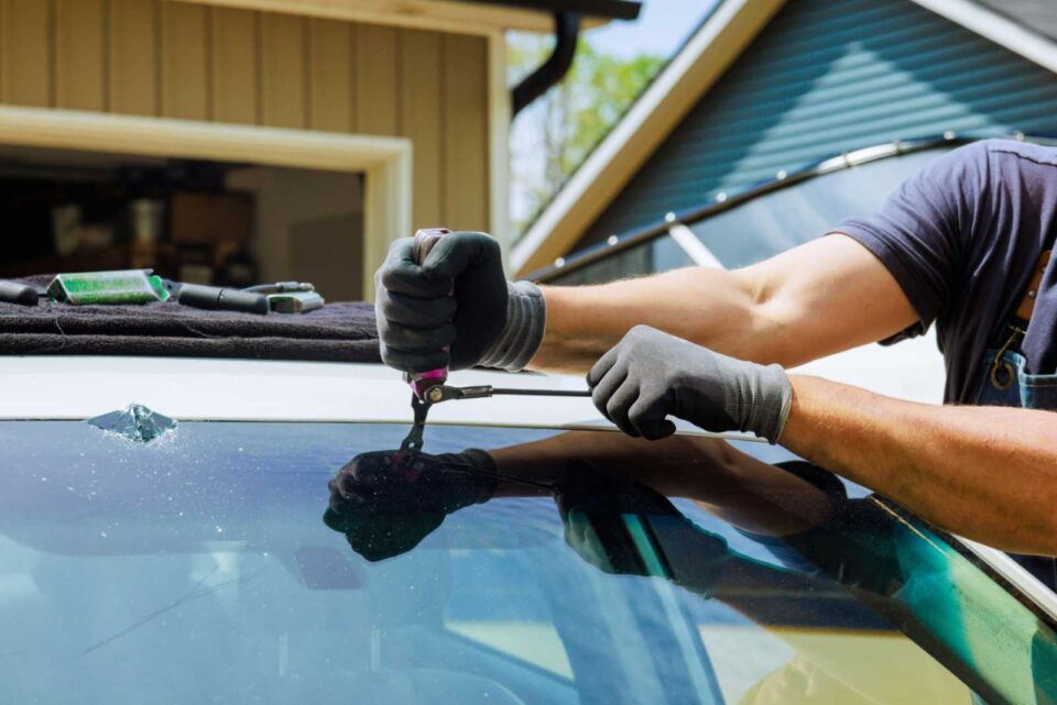 Auto glass repair technician fixing a cracked windshield in Dickinson, ND