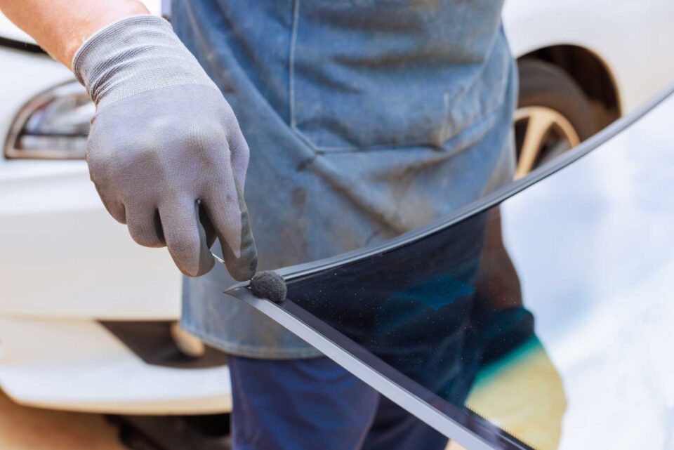 Auto glass replacement technician installing windshield in Dickinson, ND